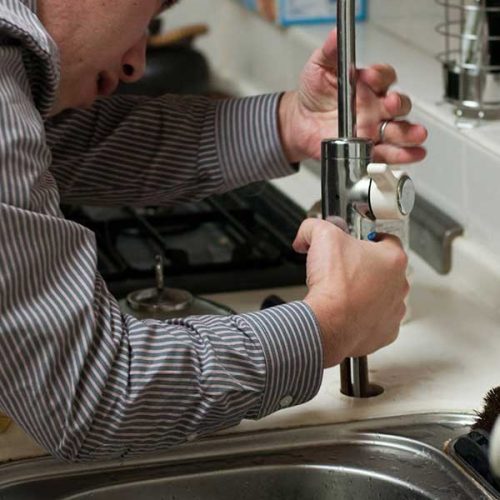 plumber replacing kitchen faucet